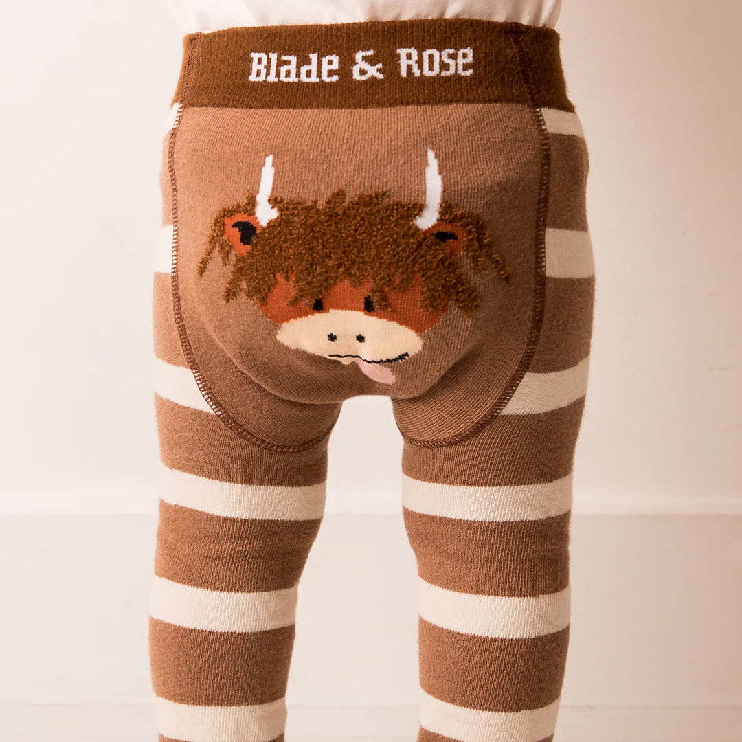 Baby wearing Neutral Highland Cow Leggings featuring Hamish Highland Cow design on the back.