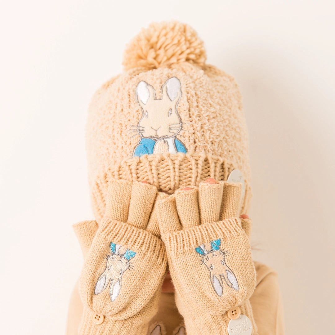 Neutral Peter Rabbit™ winter hat with pom-pom and embroidered bunny detail on soft knit fabric.