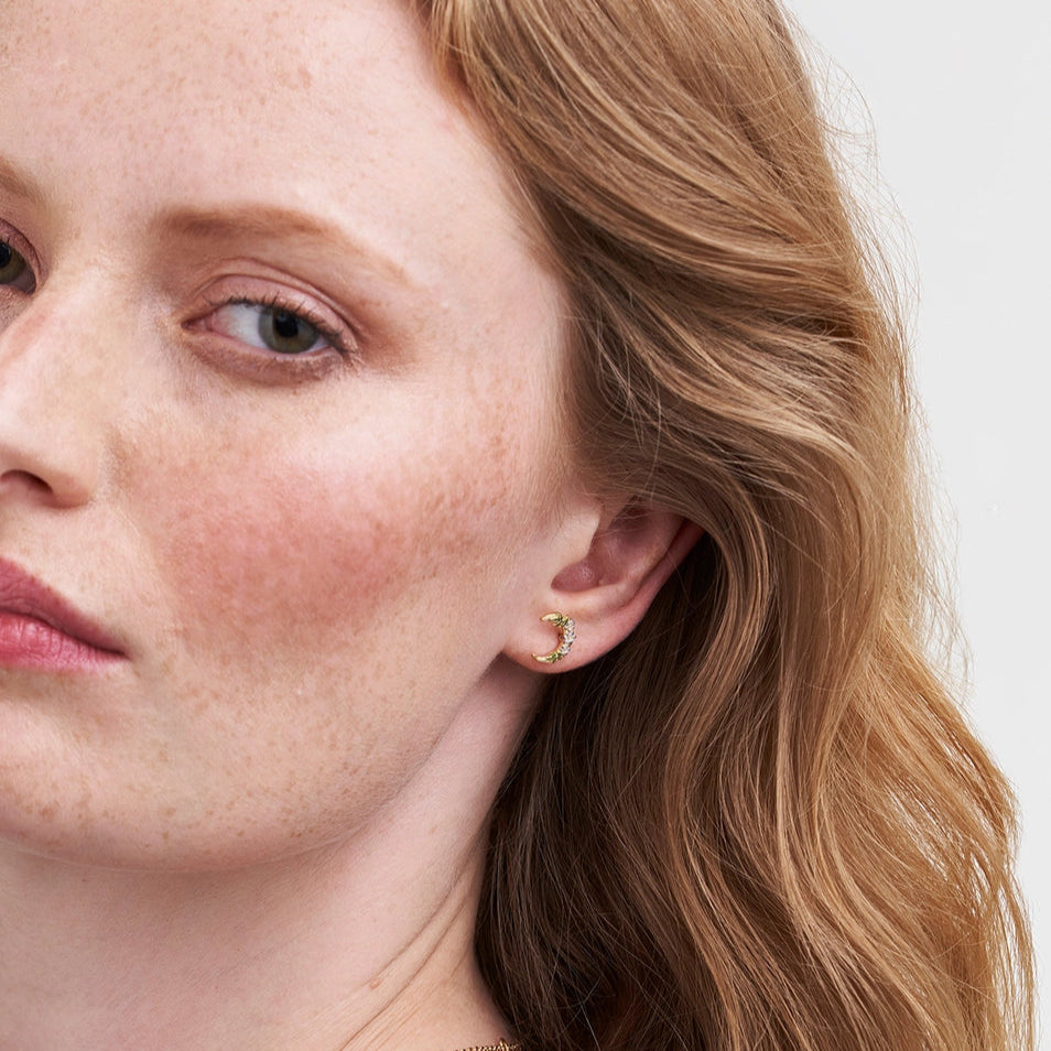 Model wearing Nightshade Moon crescent gold stud earrings.