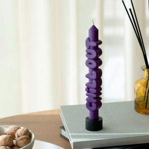 Indigo Chill Out candle displayed upright on a book stack, adding quirky charm to a modern table setting, perfect for gifting or décor.
