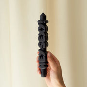 Hand holding black ‘Hey Sexy!’ taper candle, showcasing bold 3D lettering and handmade sculpted wax finishHand holding black ‘Hey Sexy!’ taper candle, showcasing bold 3D lettering and handmade sculpted wax finish.