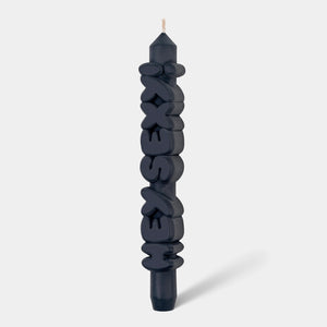Studio shot of 9-inch black ‘Hey Sexy!’ taper candle with raised lettering, handmade from soy-paraffin wax blend.
