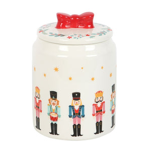 Nutcracker Christmas storage jar featuring colourful soldier design and glossy red bow lid, perfect for storing biscuits and festive treats.