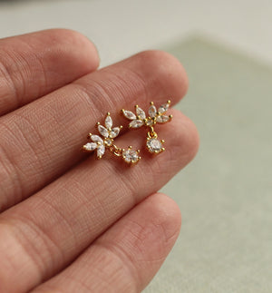 Hand holding the Oak Leaf Stud Earrings, showing their dainty size and intricate cubic zirconia setting.