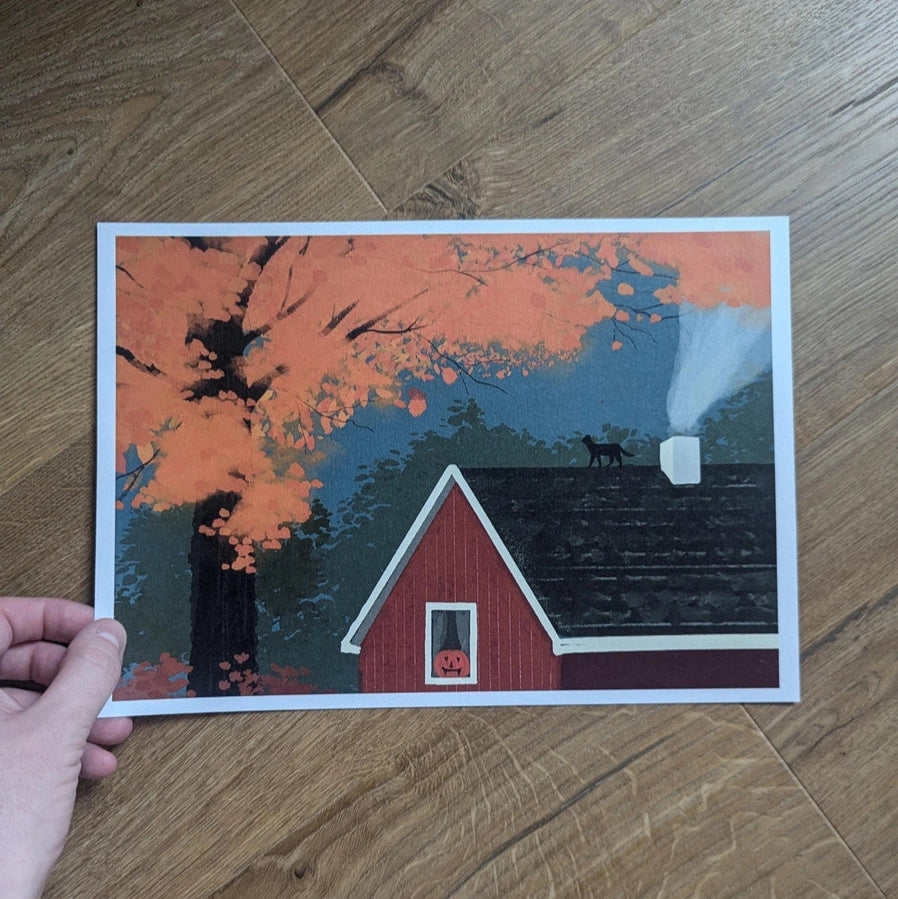 Close-up of October Landscape Art Print showing autumn cabin scene with orange leaves and black cat on roof.