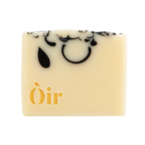 Single Òir soap bar with tear-shaped charcoal design and elegant gold embossed logo.
