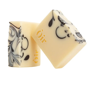 Two Òir natural soap bars stacked, highlighting hand-poured swirl detail and gold logo.