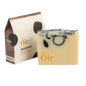 Òir soap bar paired with its recyclable packaging, featuring gold branding and rich black design.