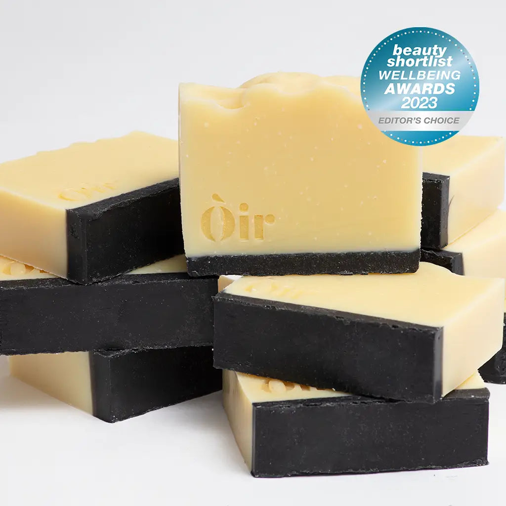 Stack of Òir Cinnamon & Lemongrass Soap bars with gold logo and charcoal base, featuring 2023 Beauty Shortlist Wellbeing Awards Editor’s Choice badge.
