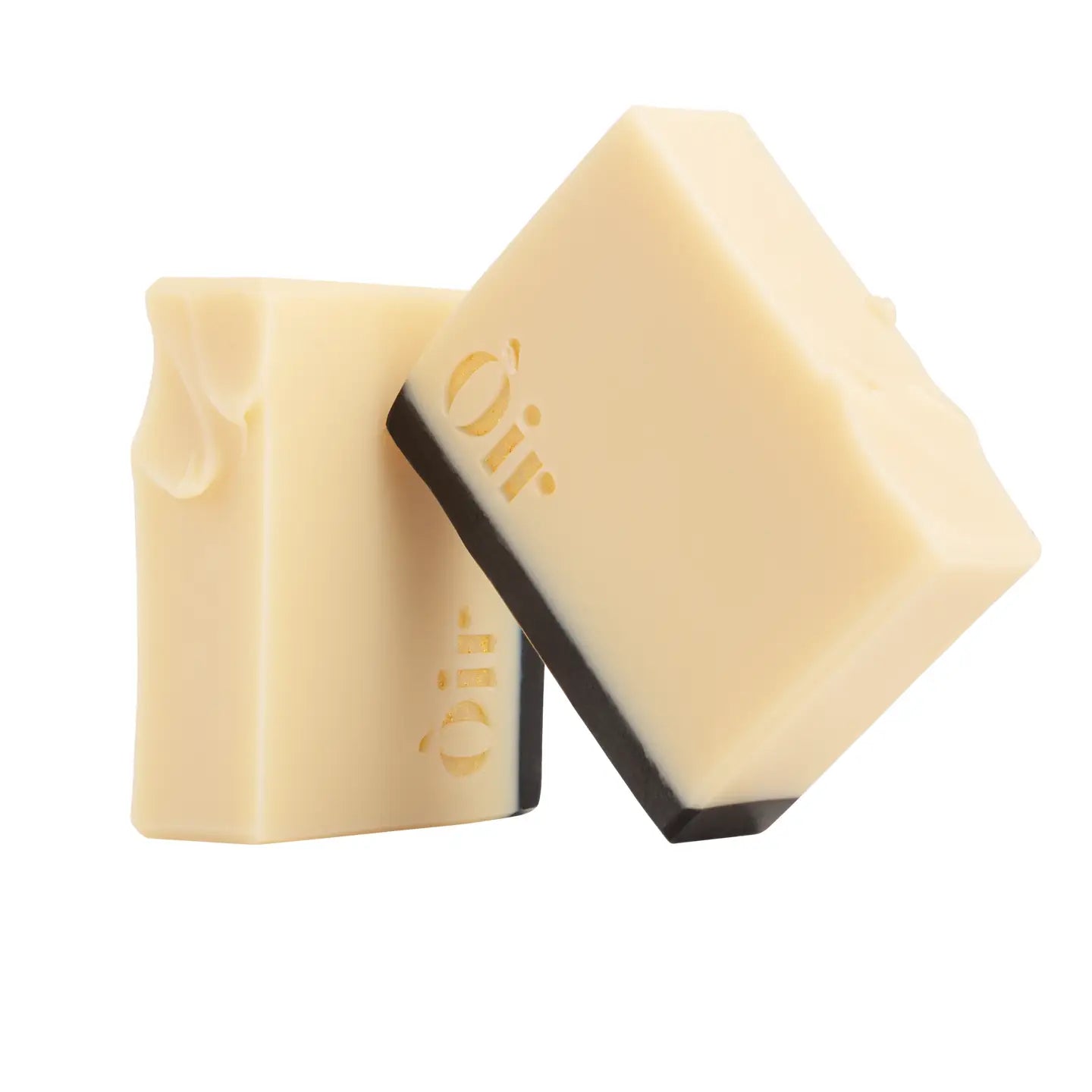Two Òir Cinnamon & Lemongrass Soap bars stacked at an angle, highlighting textured top and embossed gold logo.