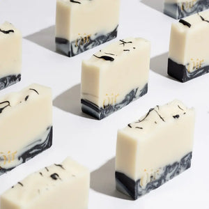 Artisan vegan soap bars with black marbling and embossed Òir branding.