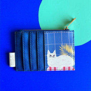 Back of cat zip purse featuring relaxed white cat illustration on dark blue with gold leaves.
