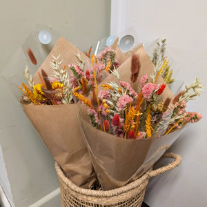 Close-up of a vibrant dried flower bouquet with warm orange, pink, and golden hues.