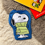Peanuts Snoopy Jumper mini hot water bottle on rug with books.