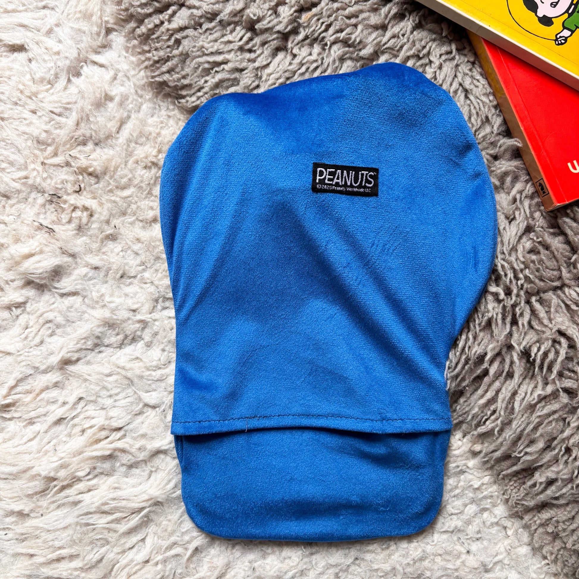 Back view of Peanuts Snoopy Jumper mini hot water bottle with Peanuts logo.