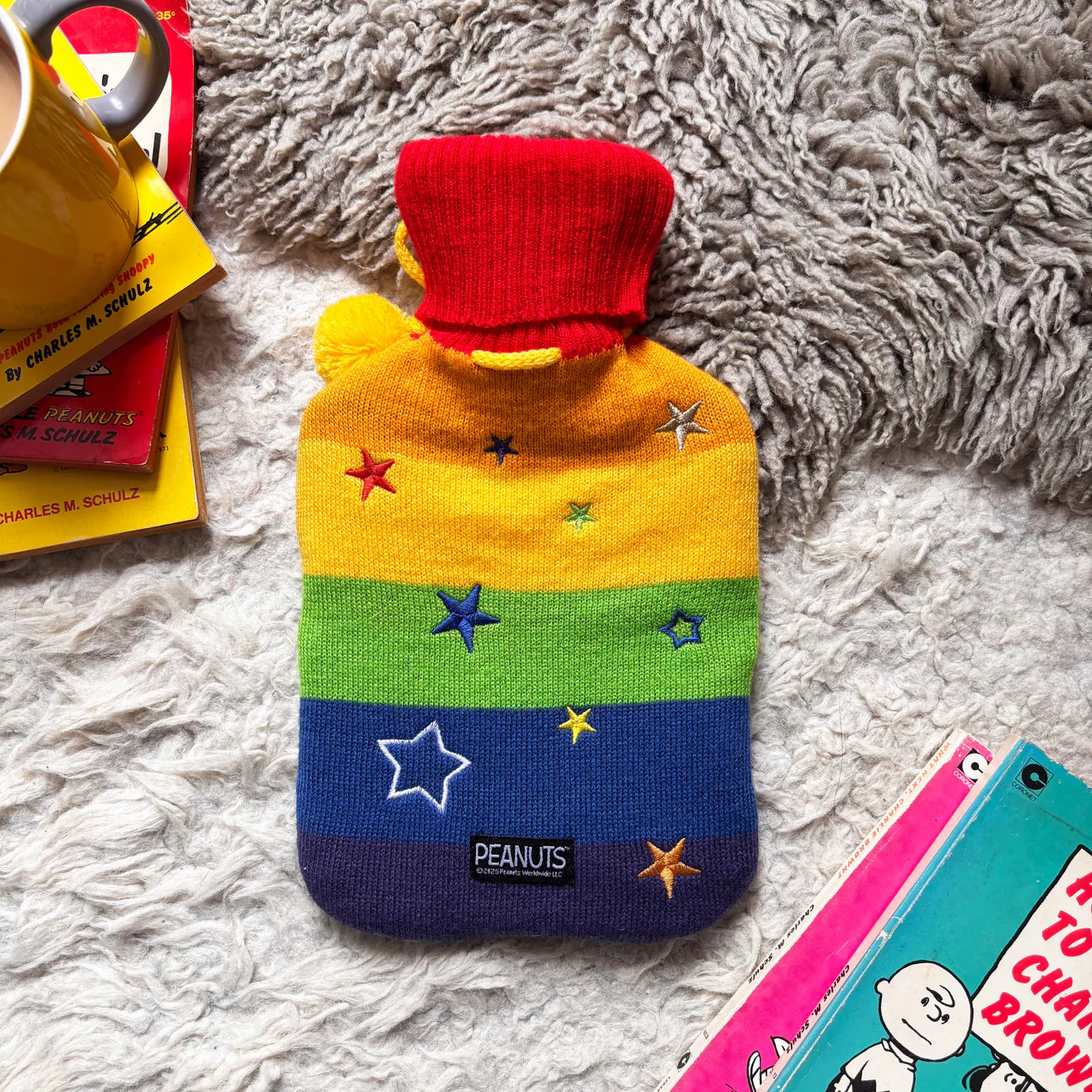 Back view of Snoopy Rainbow Hot Water Bottle showing rainbow stripes and embroidered stars.