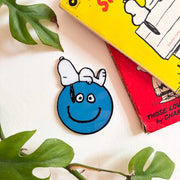 Peanuts Snoopy Smiley compact mirror on table with Peanuts books.