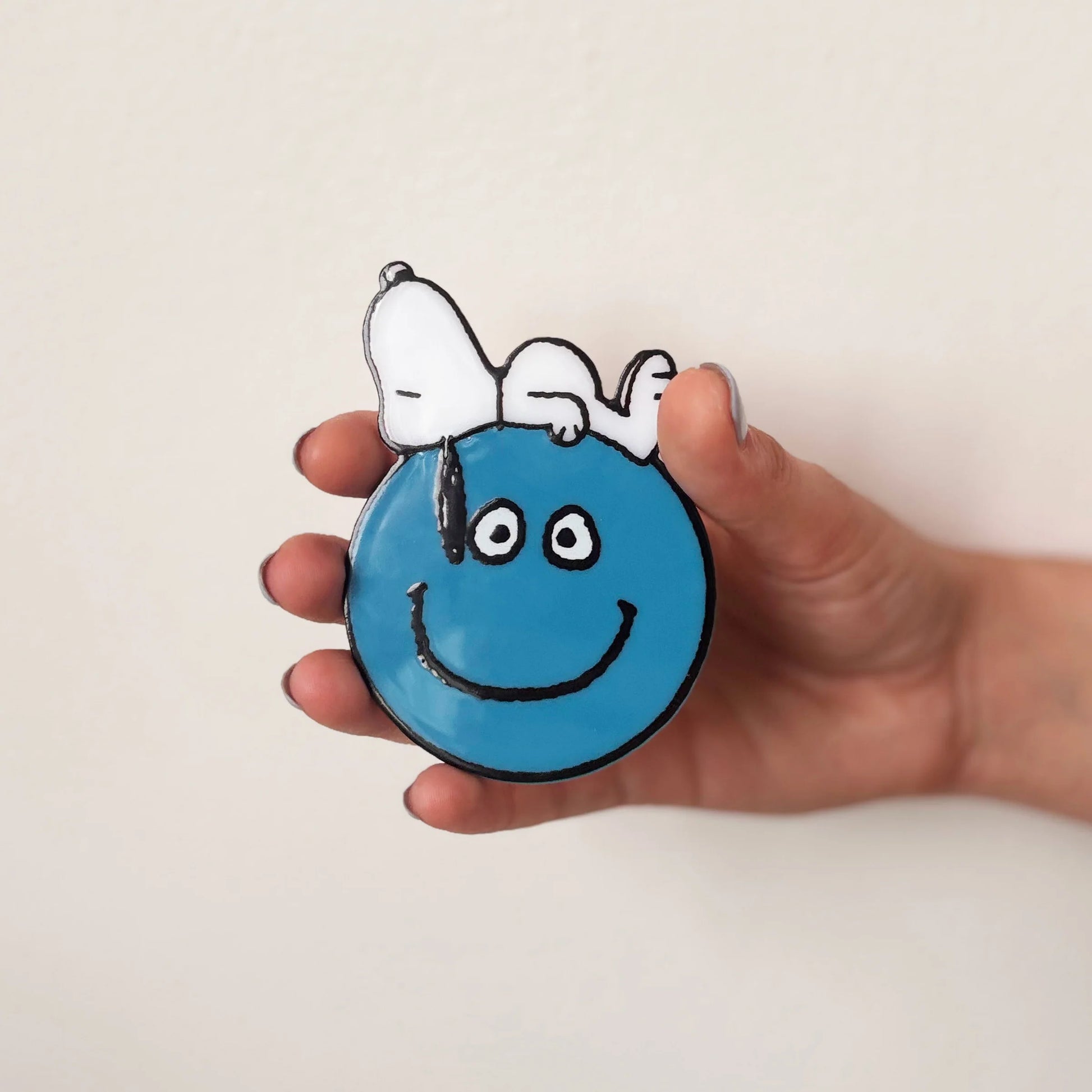 Hand holding Peanuts Snoopy Smiley compact mirror.