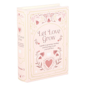 Front view of pink faux book storage box with heart and flower design.
