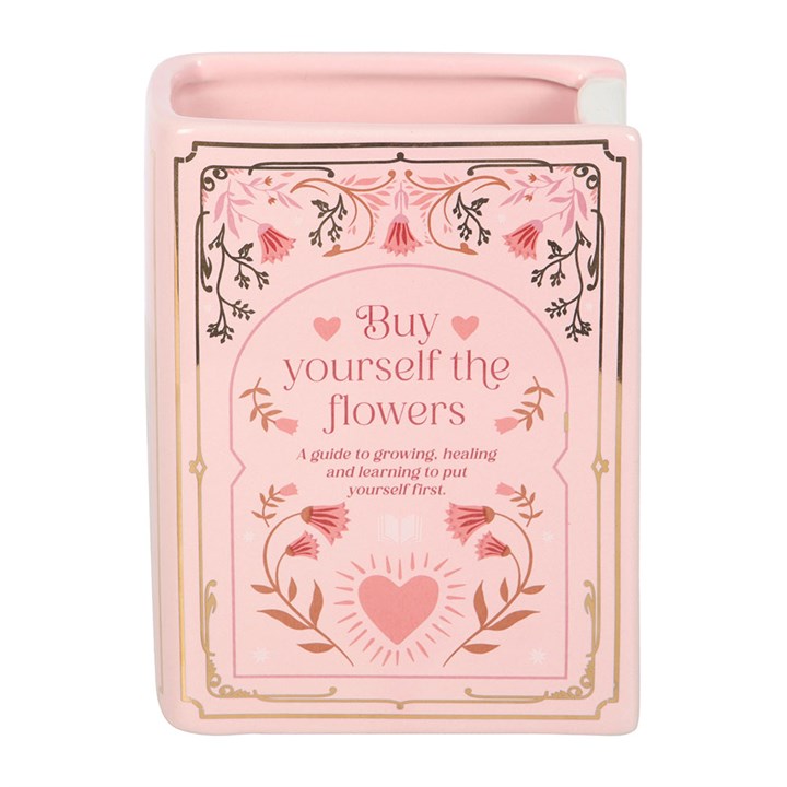 Front view of pink ceramic book shaped vase with floral design and heart motif – quirky home accessory for book lovers.