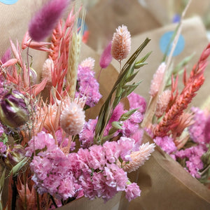 A close-up of pink dried flowers and grasses, showing intricate floral textures.