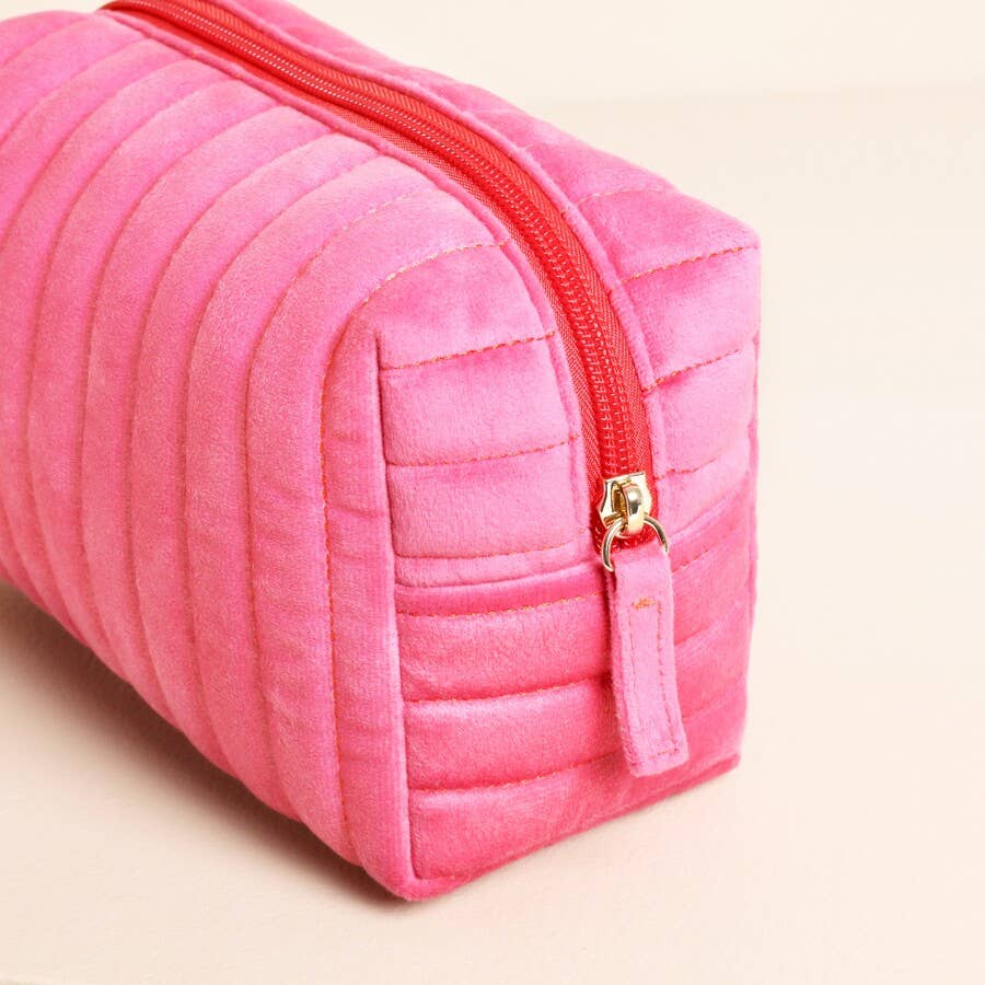 Pink and red velvet bow makeup bag with gold zip detail.