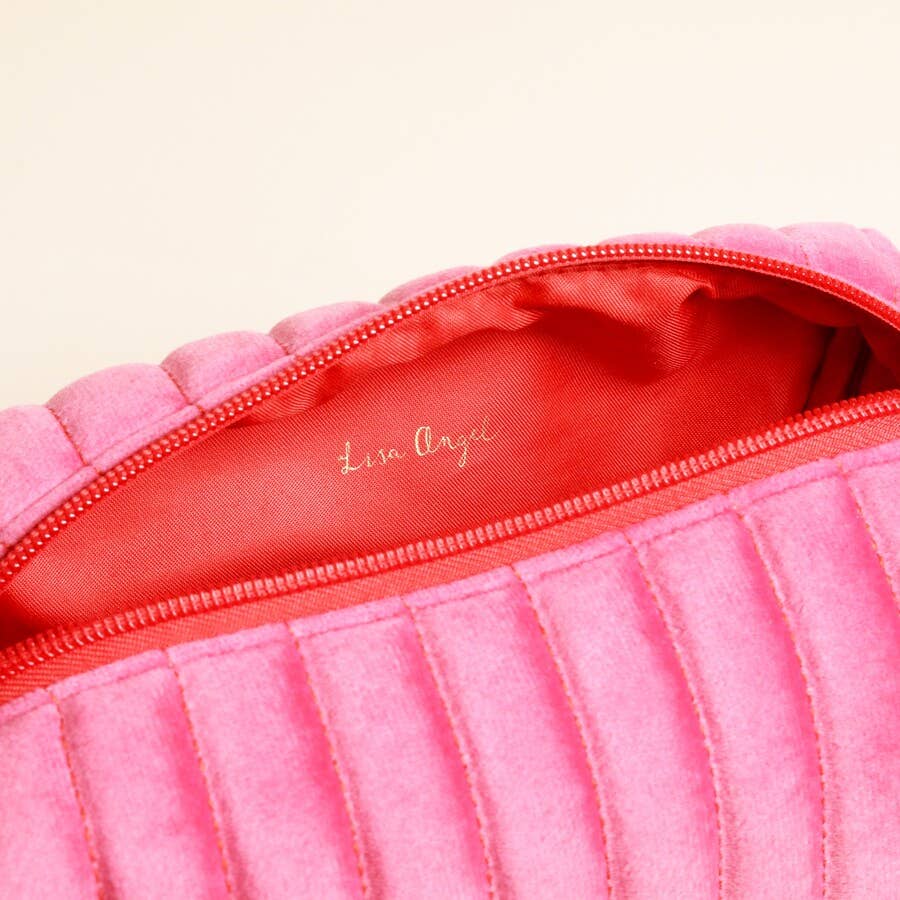 Inside view of pink velvet makeup bag with red lining and “Lisa Angel” logo.