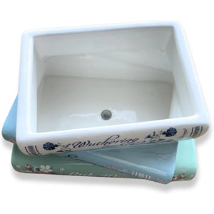 Close-up of ceramic book planter showing drainage hole and interior.