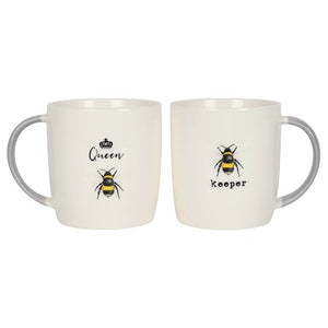 Set of two white mugs. The one on the left says queen bee while the one on the right says bee keeper.