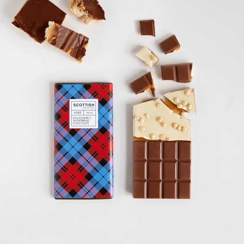 Millionaire’s Shortbread Chocolate Bar with white chocolate shortbread base, caramel centre, and milk chocolate top, wrapped in red and blue tartan paper.