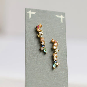 Front-facing display of mismatched rainbow earrings on a grey card, highlighting vibrant colours and detailed gold-plated sterling silver settings.