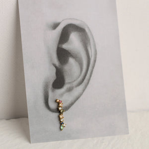 Single rainbow earring styled on a monochrome ear illustration, showing how the colourful stones curve naturally along the ear lobe.