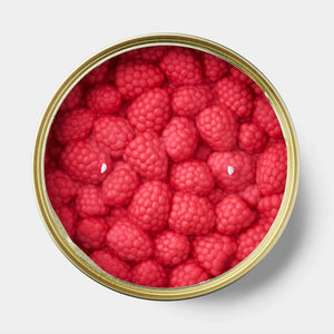 Top-down view of Candlecan’s raspberry candle showing hyper-realistic red raspberry wax shapes with three visible wicks inside a gold tin.