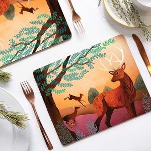 Red Deer Placemat featuring a woodland scene with a stag and deer, designed by Charlotte Anne, set on a rustic dining table.