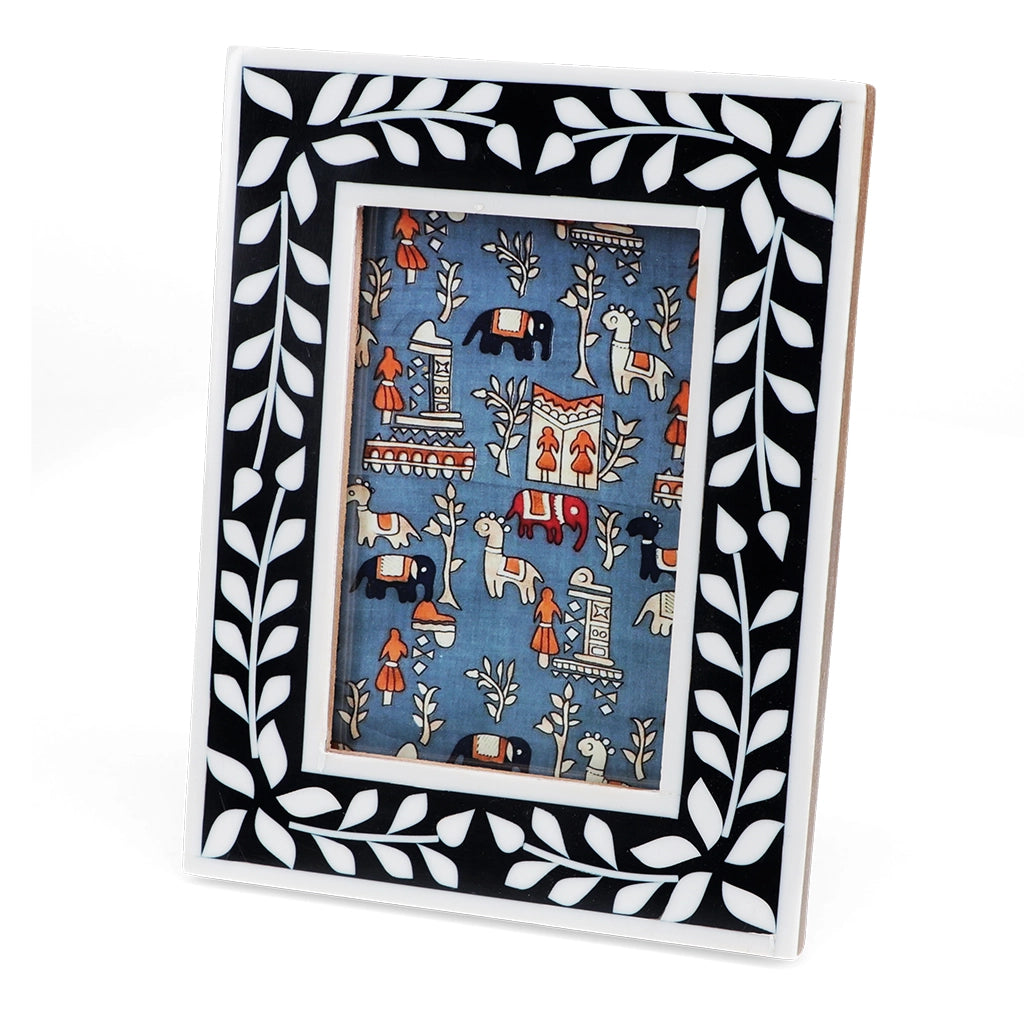 Front angled view of navy blue resin picture frame with white leaf border and decorative insert.