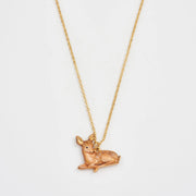 Resting Fawn Gold Chain Necklace pendant close-up on white background.