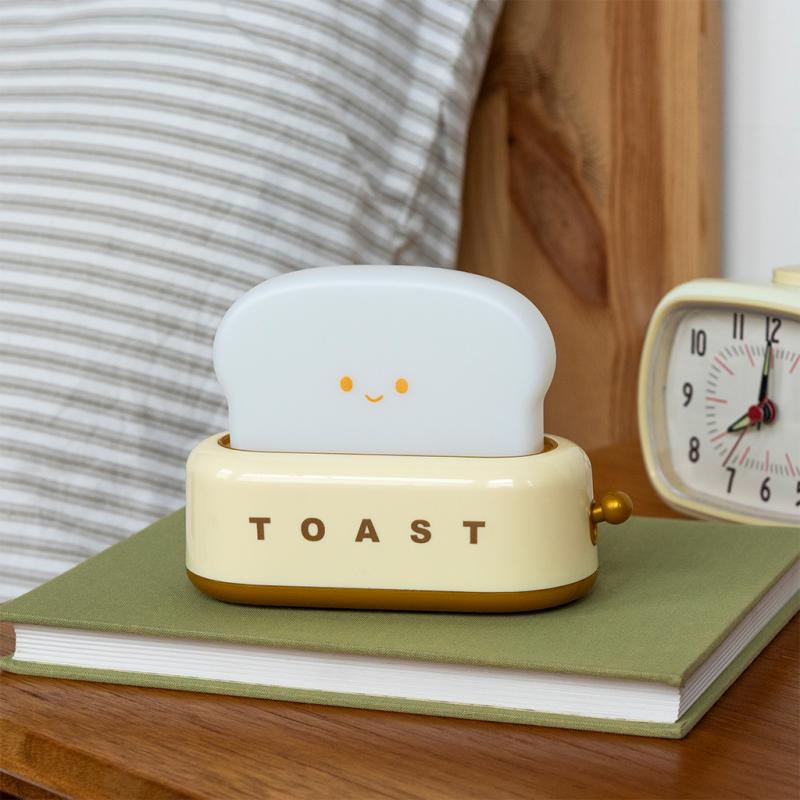 Smiling kawaii toaster night light unlit on a nightstand – warm white dimmable LED.