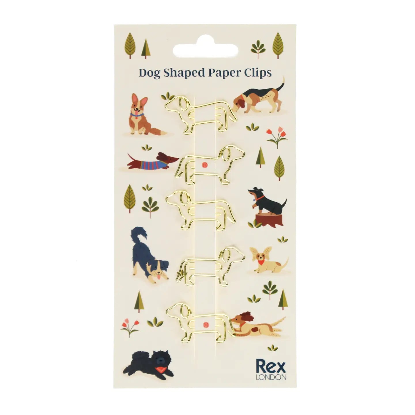 Front view of Rex London Dog Shaped Paper Clips set, featuring five gold metal clips shaped like dogs, displayed on a playful illustrated backing card with various cartoon dogs in a dog park setting.