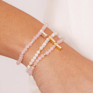 A stylish stack of rose quartz beaded bracelets featuring both gold and silver accents, promoting love and harmony.