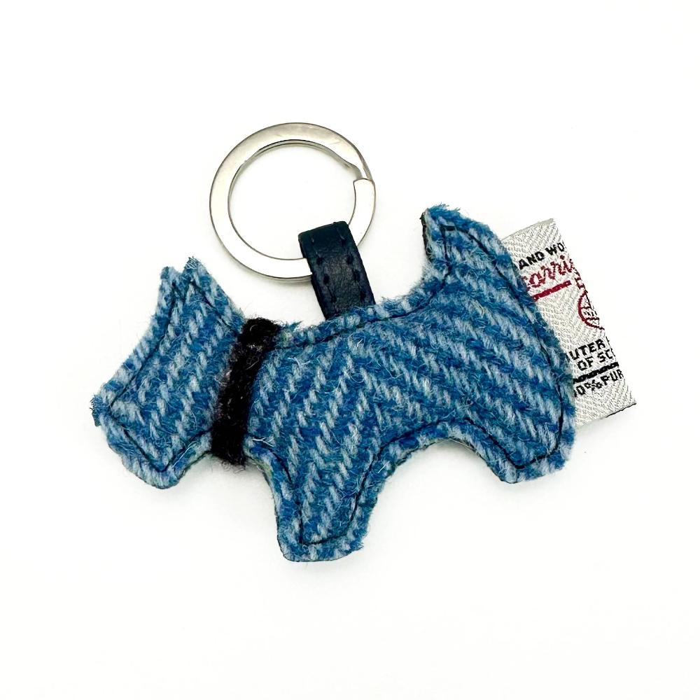 Sky Blue Harris Tweed Scottie dog keyring with woven label and silver ring, shaped like a Scottish Terrier with black collar detail.