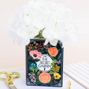 Front view of Secret Garden ceramic book vase with white flowers, featuring vibrant floral design inspired by the novel.