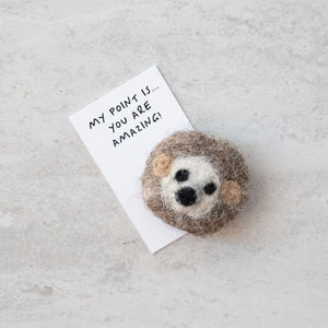 Close-up of the wool felt hedgehog placed on a note with a heartfelt message.