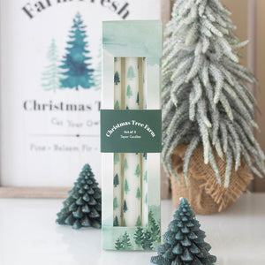 Set of three white taper candles in gift box with green fir tree pattern and Christmas Tree Farm label.