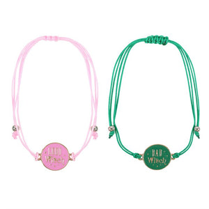 Pink Good Witch bracelet and green Bad Witch bracelet laid flat.
