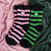 Set of 2 fluffy striped socks with pink ‘Good Witch’ and green ‘Bad Witch’ designs on a cosy blanket – witchy gift set.
