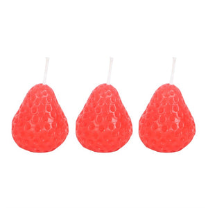Studio shot of three bright red strawberry-shaped candles with wick detail, displayed in a neat row on a white background.