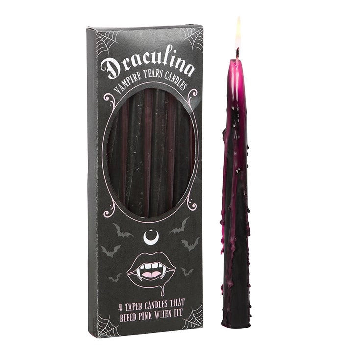 Box of Vampire Tears candles with one black taper candle lit and bleeding pink wax down the sides – spooky Halloween decor.