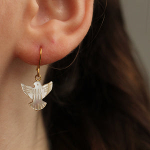 A model wearing the short-length Pearl Dove Bird Earrings in gold.