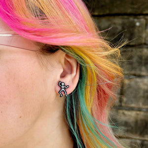 Model wearing Silly Loaf Skeleton Stud Earrings, with vibrant multicoloured hair.