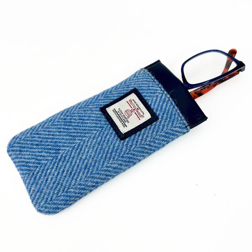Sky blue Harris Tweed glasses sleeve with glasses peeking out and Harris Tweed label on the front.